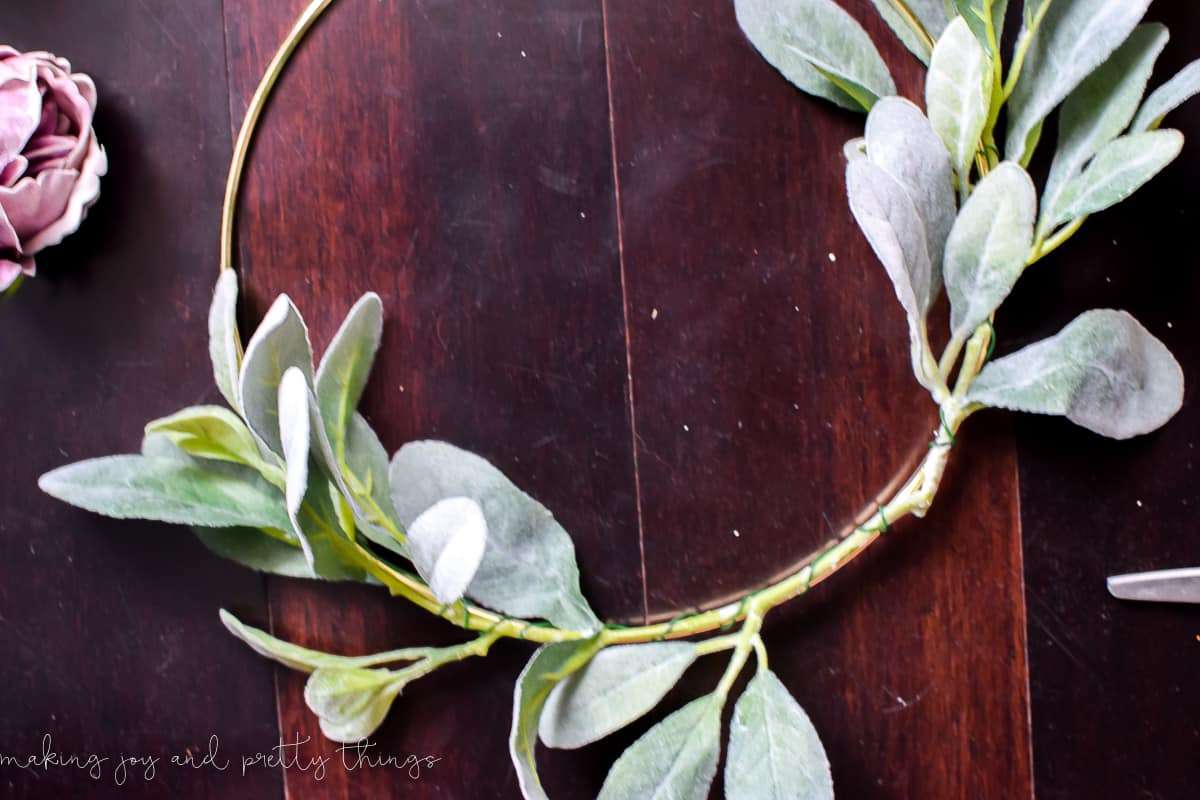 Attaching lamb's ear using floral wire to the DIY gold ring wreath 