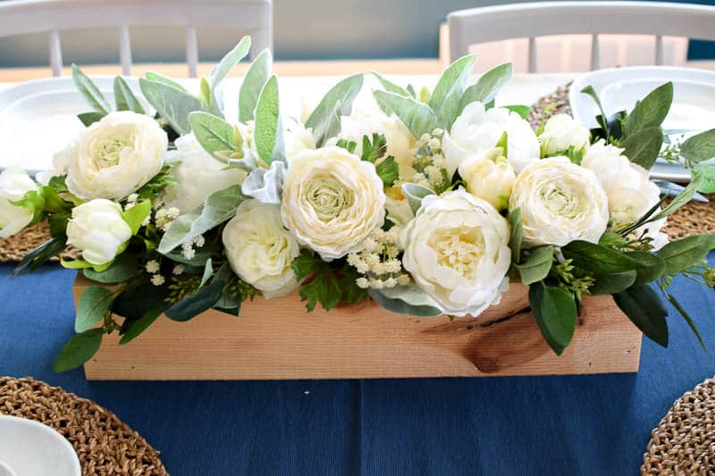 See how I made a simple wooden box to use as a centerpiece and filled it to the brim with lovely green and neutral flowers. It's the perfect farmhouse neutral floral centerpiece that can be used in all seasons!