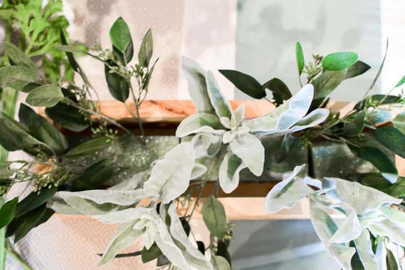 Adding in second greenery into the floral foam to provide depth and variety in the DIY wooden box centerpiece