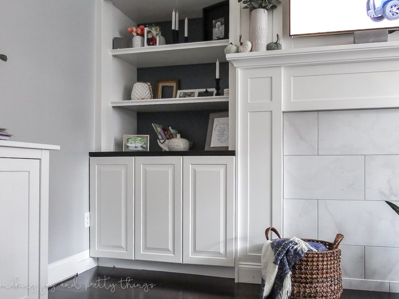 Organizing a messy living room using IKEA built ins around fireplace to create bookshelves and cabinet storage space.