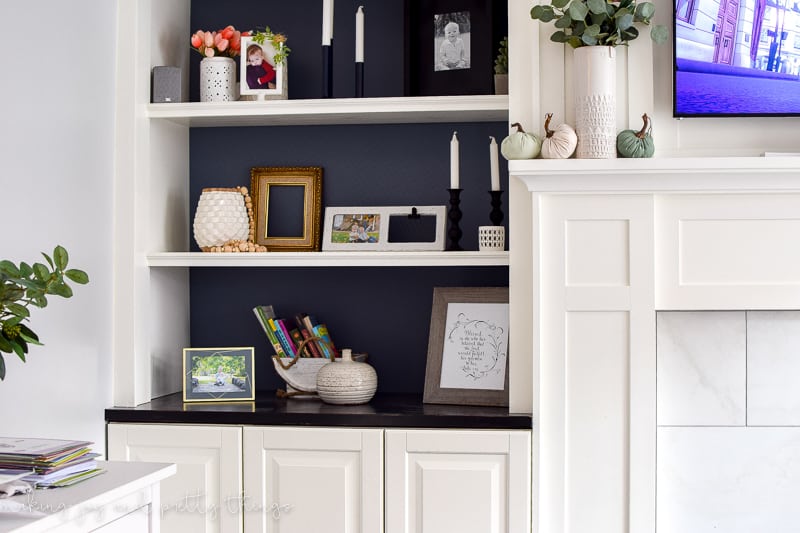 These DIY built in bookshelves around fireplace are great for decor and family photos. IKEA wall cabinets are great as a living room storage option.