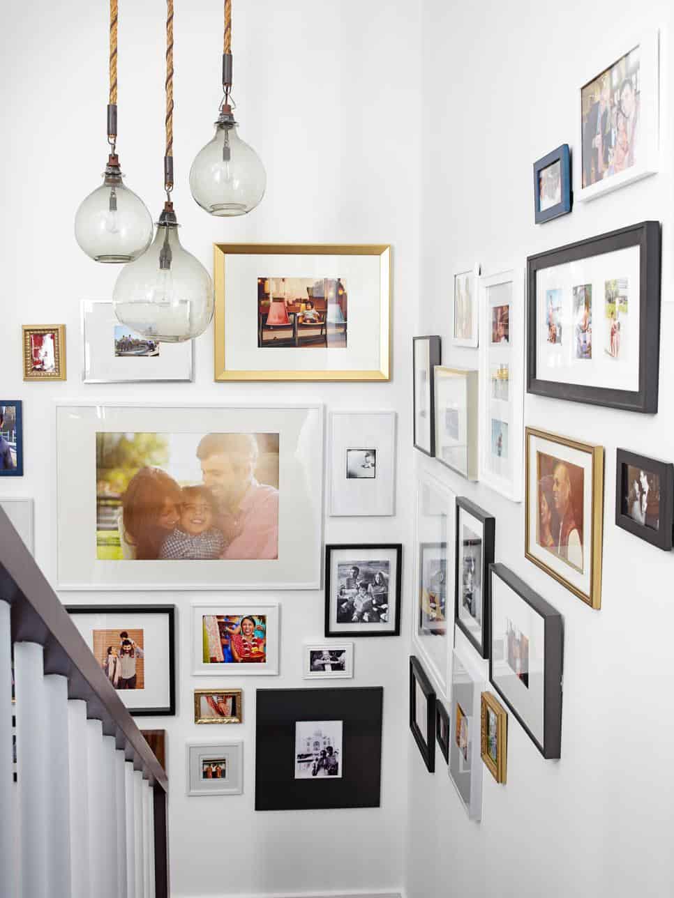 If you are wondering how to display family photos in a stairwell this eclectic and tasteful gallery wall can be a real game changer.