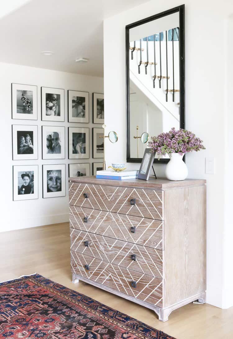 If you are looking for a tasteful way to display family photos in a hallway these black and white pictures do the the trick hung in this way.