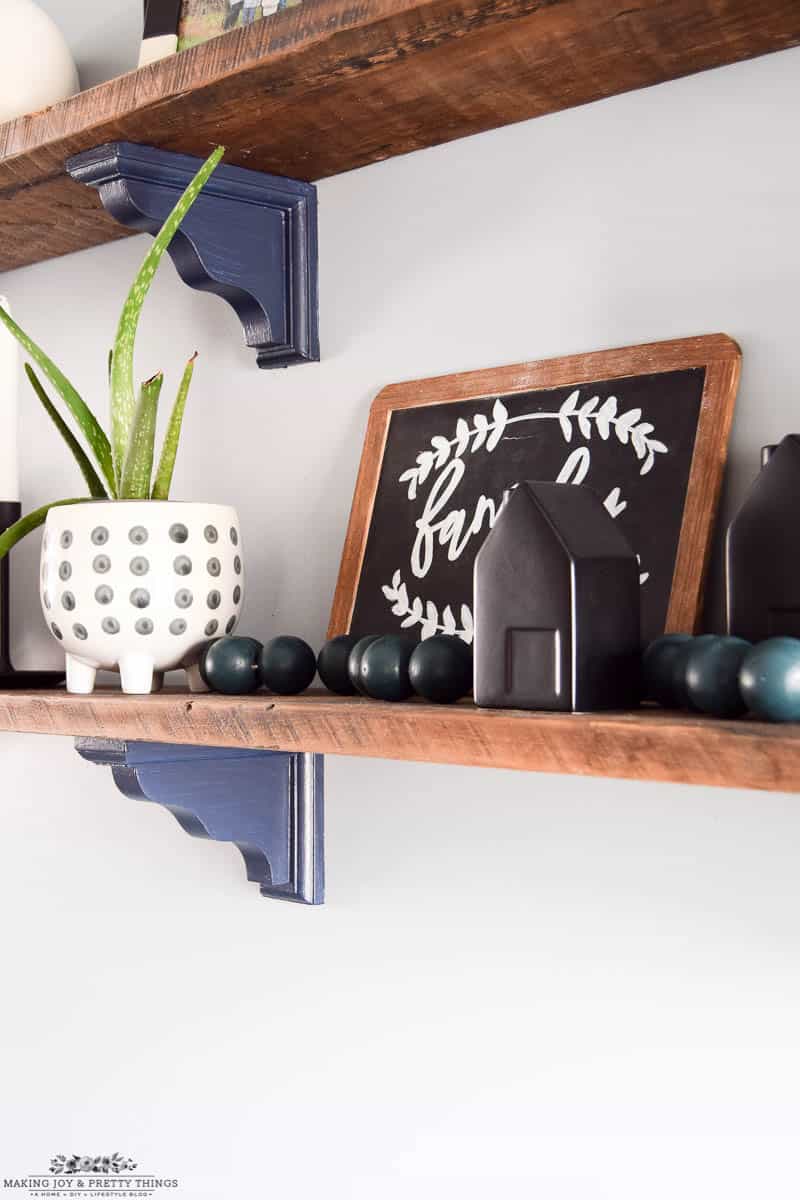 Rustic shelves designed with chalkboard vases and a diy wooden ball garland in a farmhouse style