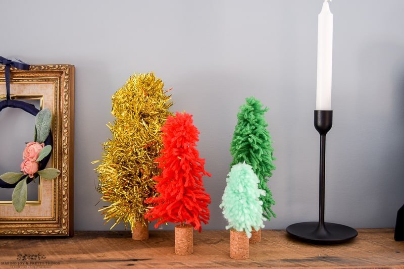Decorating rustic farmhouse shelves in a dining room is easy with these tiny colorful Christmas trees and Candle holders