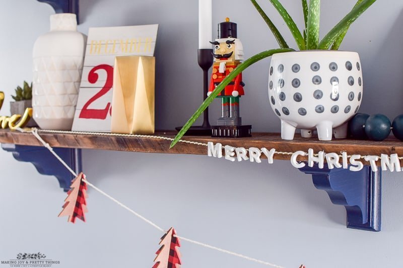 Merry Christmas garland on rustic farmhouse shelves decorating a dining room for Christmas