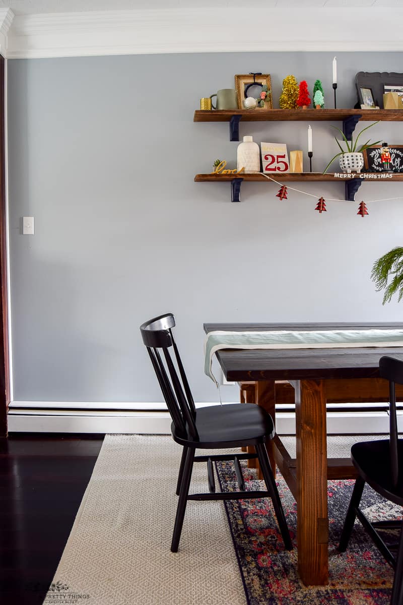 Classic dining room chairs with a bench for a dining room table on a taupe rug with a decorative rug on top