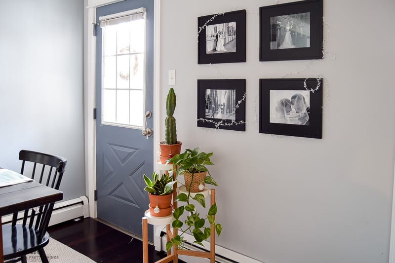 View of a dining room with greenery and photo graphs framed as an over all dining room Christmas decor design