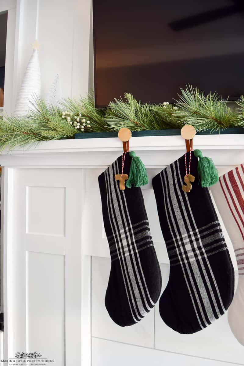 Gold stocking letter labels hanging from black and green plaid stockings 
