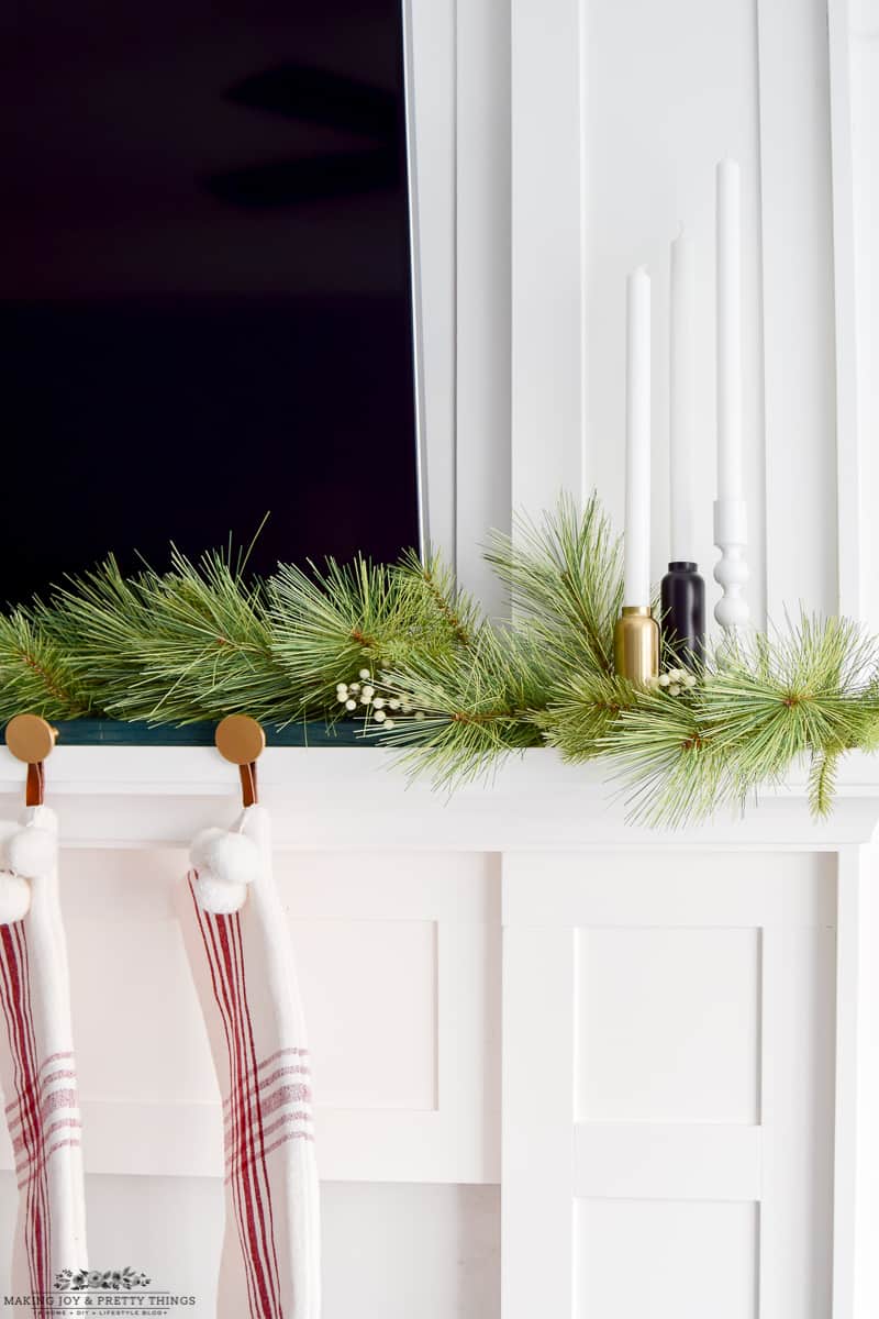 Adding candlesticks to a mantle for a variety of decor to balance a mantle with Christmas pieces
