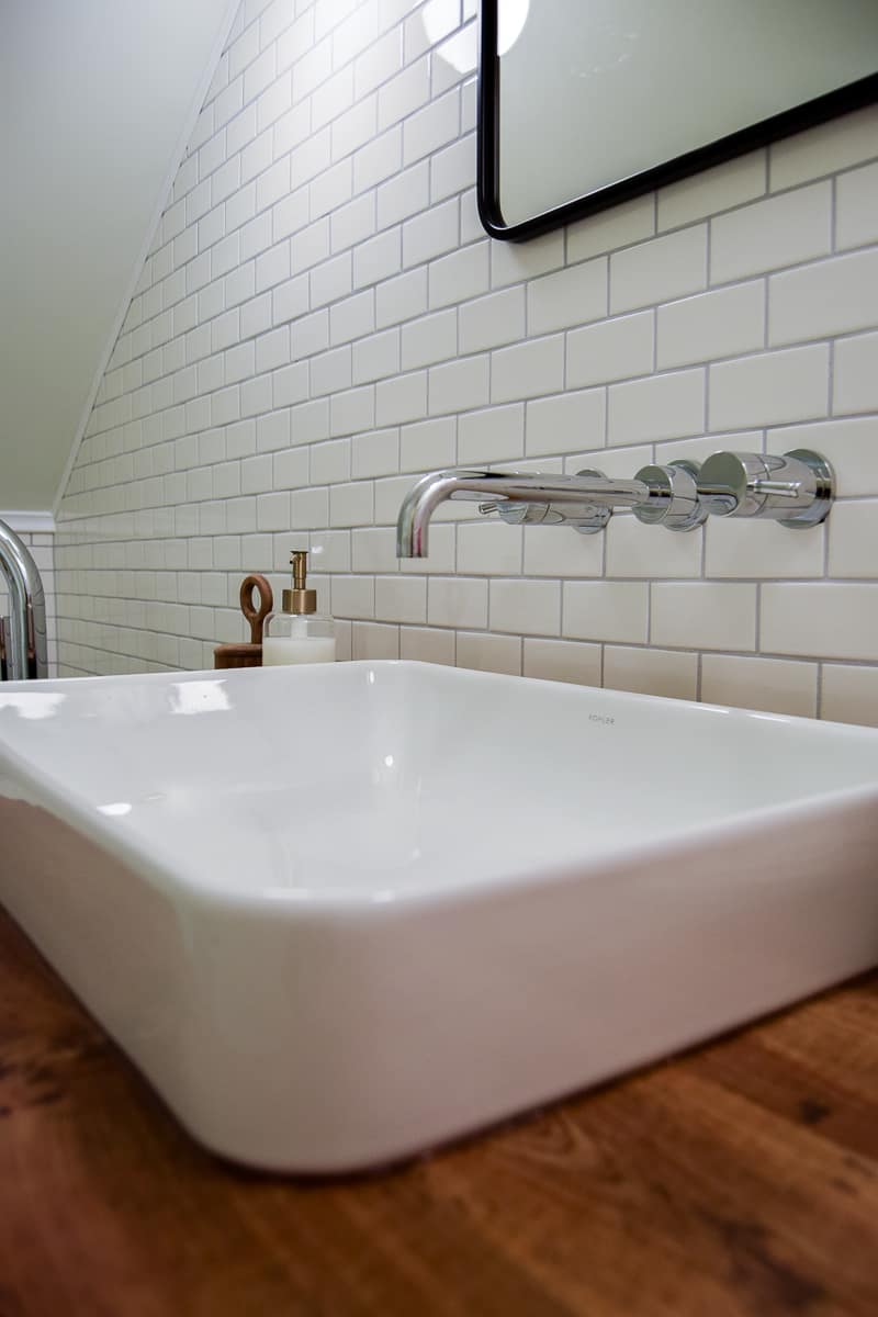 Our sleek and modern white porcelain sink and silver faucet installed in our vintage modern bathroom.