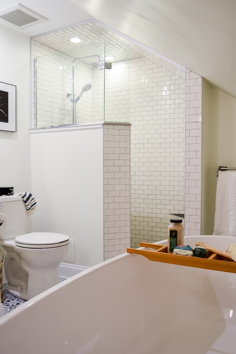 Our modern vintage bathroom, the view from the bathtub shows the walk-in shower, tiled with white subway style tile, and the toilet area.