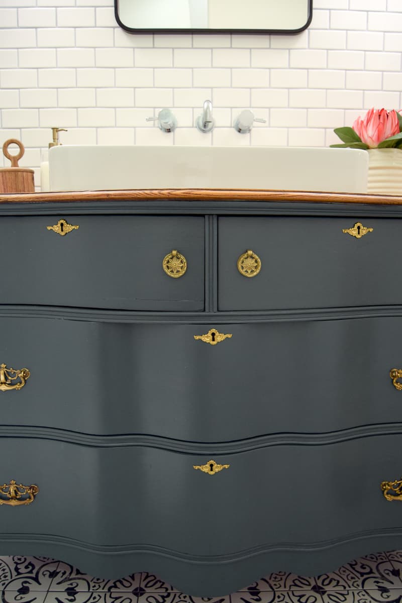 A close up look at the gorgeous shape of the vintage dresser we converted to a bathroom vanity, painted green, and installed a sink in. I love the gold hardware on this dresser!