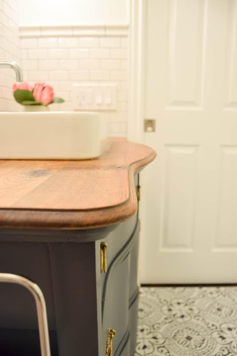 A closer look at the natural wood grain on the top of the bathroom vanity, and the smooth inlay of the porcelain sink we installed.