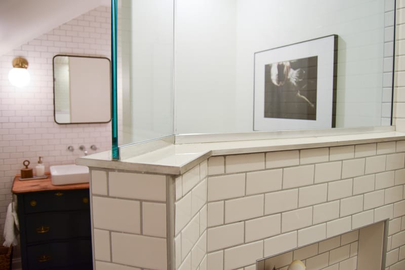 The interior wall of our walk-in shower: the shower wall is about chest-high, and is completed with shower glass up to the ceiling, giving this modern vintage bathroom an open, airy feel.