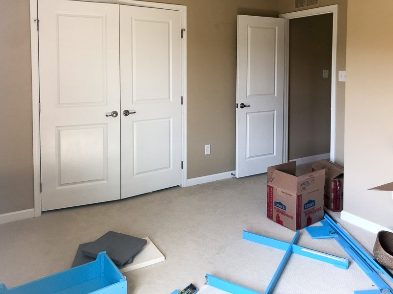 Girl's bedroom with tan walls and white trim and doors before renovating