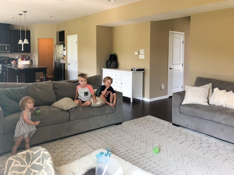 Image showing living room with white rug and grey couches that needs a renovation from builder grade fixtures