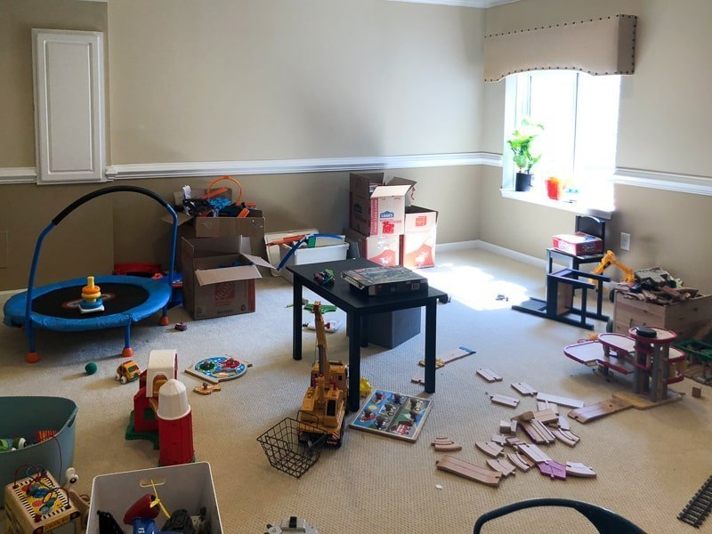 Large playroom in house that has no organization for toys and is filled with toy clutter everywhere