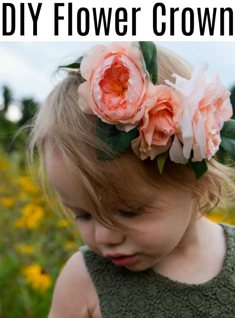 A little girl is wearing a DIY flower crown made with three faux pink hydrangea flowers. Image text  reads "DIY flower crown" in large black text.