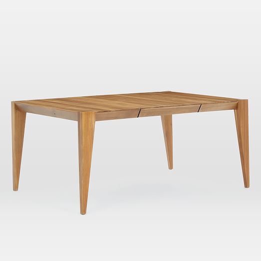 A large light natural wood dining room table from West Elm