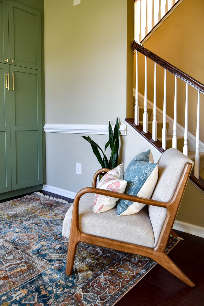 Chair with a beige paint against a green pantry used for storage in a living room renovated as an office