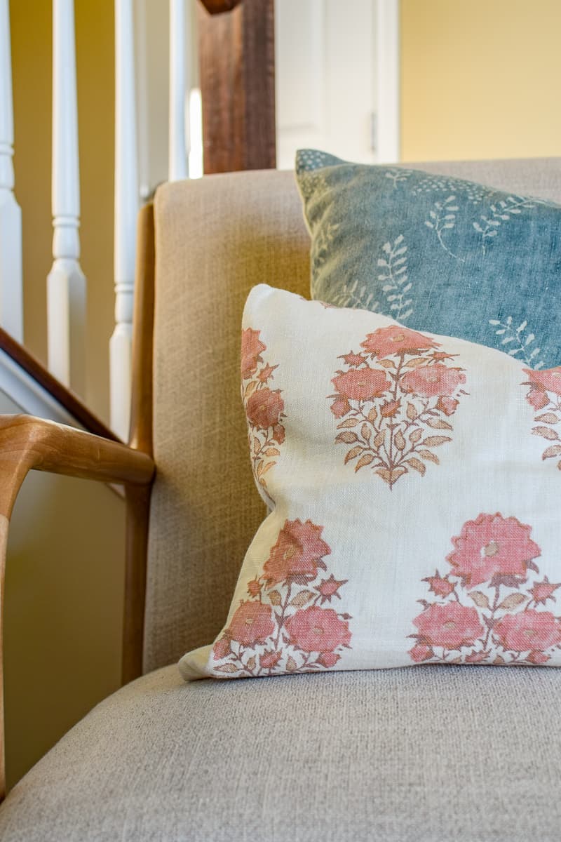 Floral pillows on a chair to ad some variety and flare to a living room converted into a modern office room