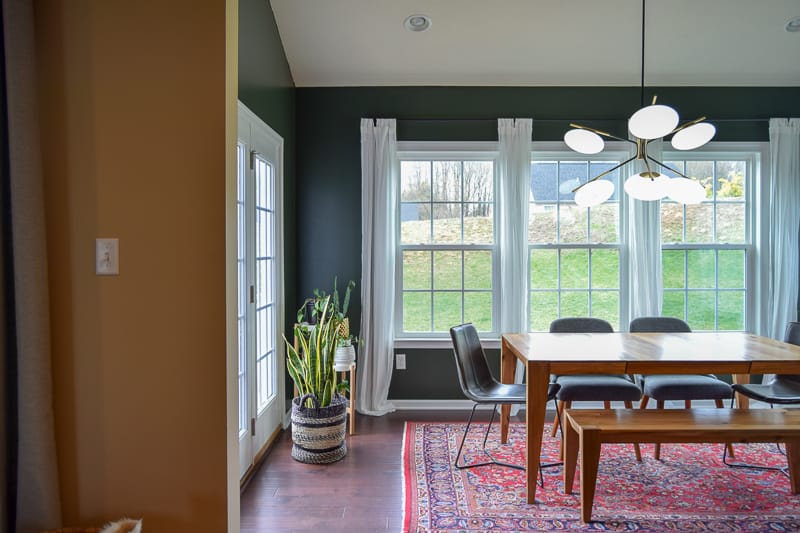 completed dining room lit up with natural and chandelier light with plants and other decor