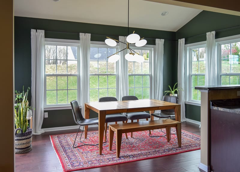 Mid century modern dining room with lots of natural light and other plants and touches with contrasting paint colors