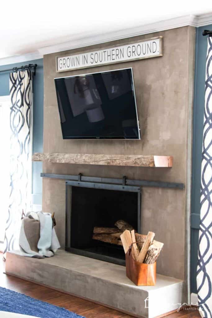 Use a live edge wood mantle to update an old fireplace that was just renovated using cement