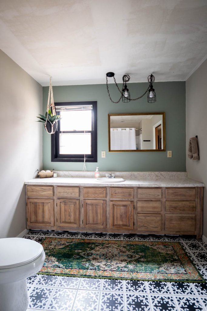 The bathroom showcases a tasteful accent of Acacia Haze green paint color, adding a subtle yet stylish touch to the space.