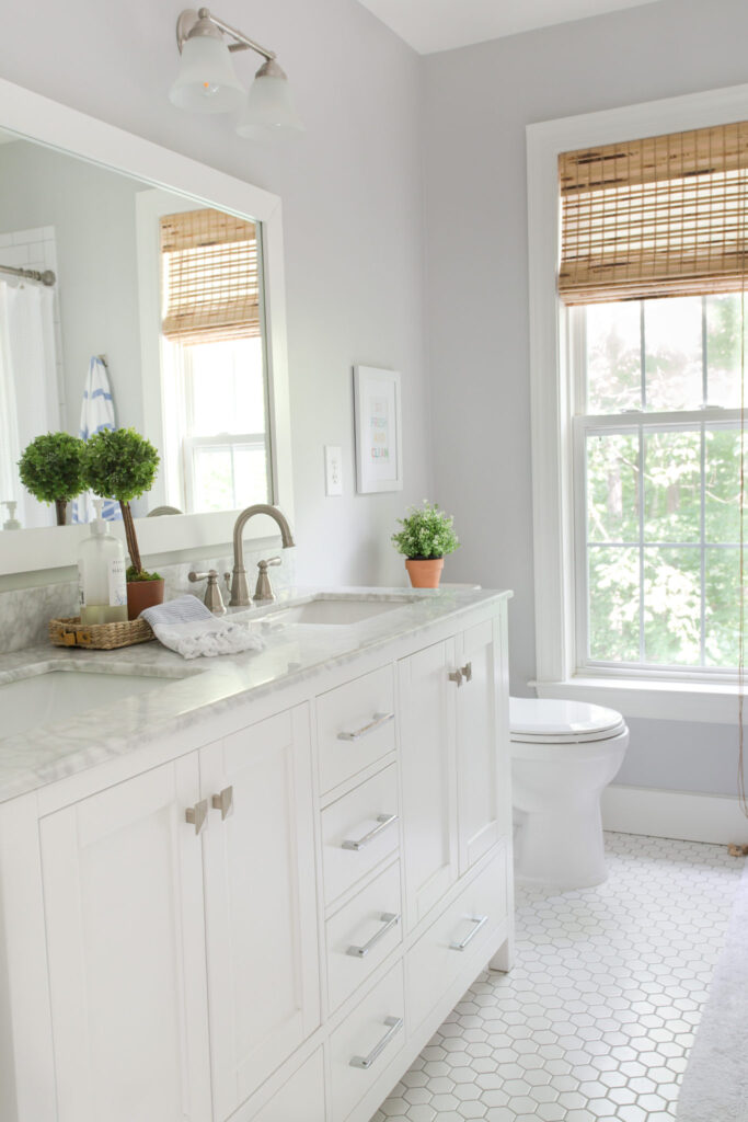 A bathroom painted with Passive SW 7064 with a white vanity, white hexagon tile floors and white trim