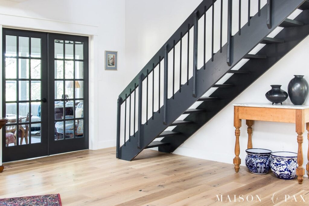 The wall is adorned with the crisp elegance of Snowbound color, while a striking black stair commands attention in the picture.