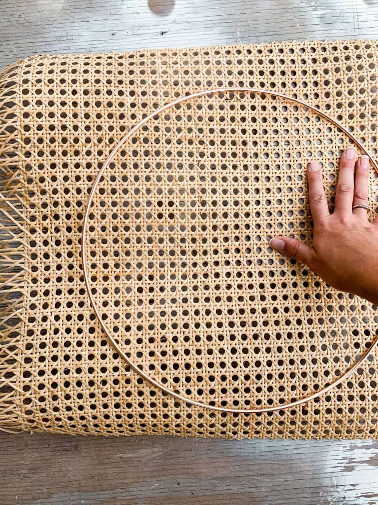 Use a hoop wreath or other circle object to trace and then cut the cane webbing down to size for your nightstand