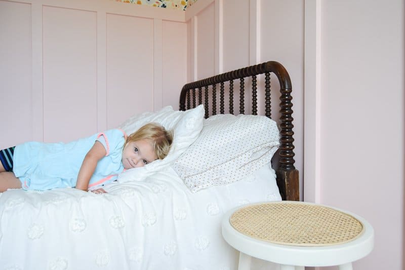 Looking for DIY nightstand ideas? I tried my hand at DIY cane projects with a DIY cane nightstand for Evie’s toddler girl room! I used a stool from Target, some spray paint, and cane to make a DIY nightstand. It’s the perfect addition to a little girl’s room if you’re looking for girl room ideas. The DIY cane nightstand was an easy DIY that adds tons of style and function to her girly room. #cane #canefurniture #diyprojects #diycanenightstand