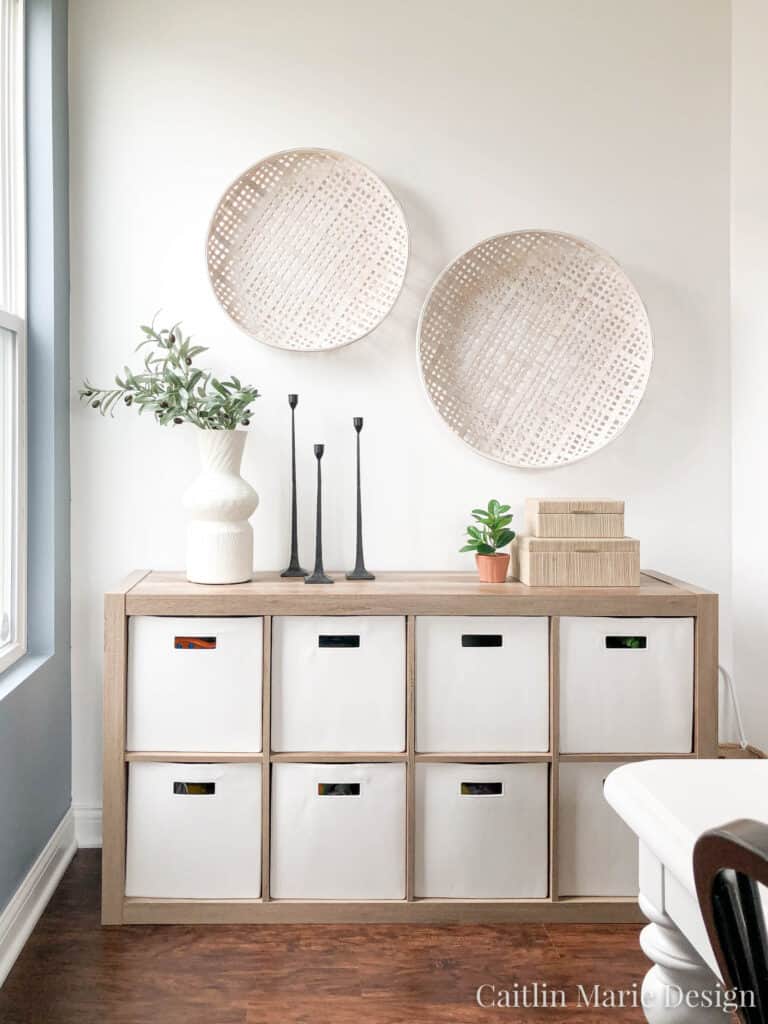 Cube storage with white bins and wood storage unit that used to store toys in the dining room, but it is decorated pretty and doesn't look like toy storage 