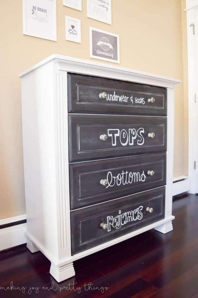 Making a plan for each of the drawers in a kid's dresser is important when organizing. This dresser has chalkboard paint on the drawer fronts with hand lettered words describing what goes in each drawer of this kid's dresser. 