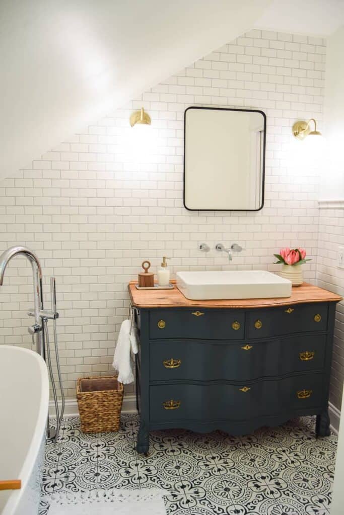 This master bathroom renovation brings together both vintage and modern interior design styles, with a focal point of this vintage dresser used as a vanity