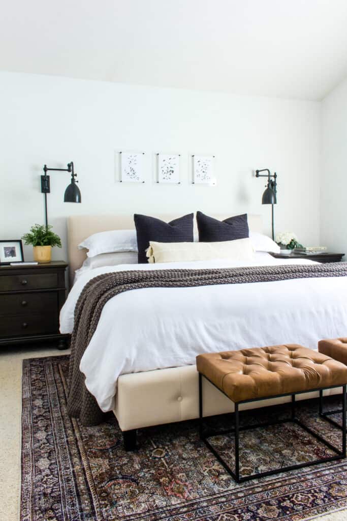 neutral bedroom with king size bed  with an 8x10 size rug under it and leather benches at foot of bed