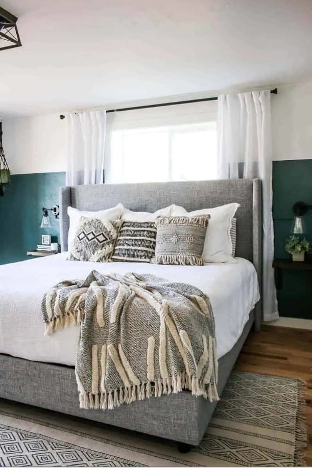 A 6x9 Rug under a King Bed can work if you're on a budget or  you have smaller bedroom. See how a 6x9 rug is styled in this boho style master bedroom under just the bottom part of the bed frame.