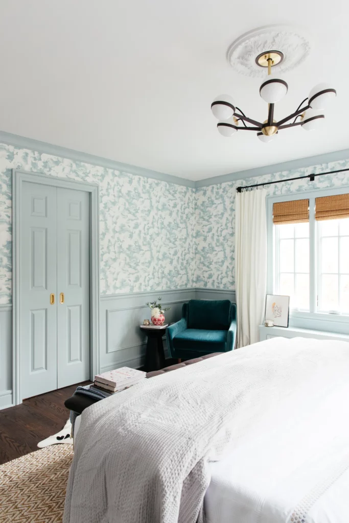 BM Smoke blue green paint color used on crown molding, wainscoting paneling and doors with matching patterned wallpaper in a bedroom 