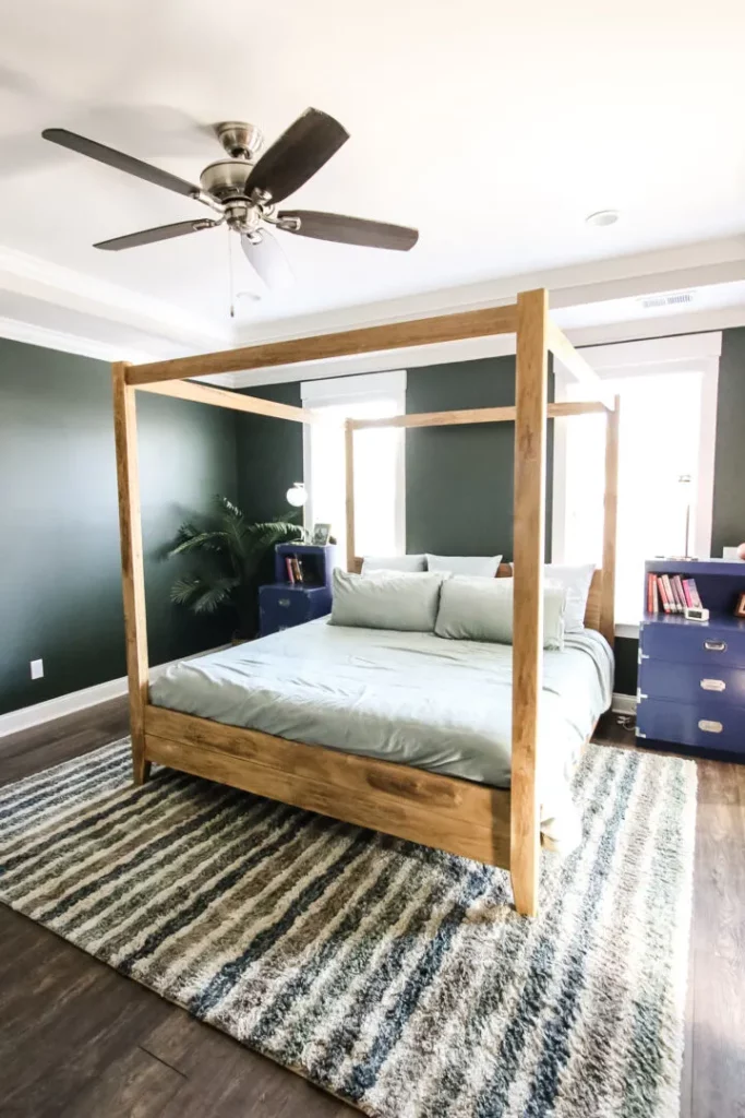 A photo of a green wall in a bedroom painted an eminently peaceful color using Behr north woods.
