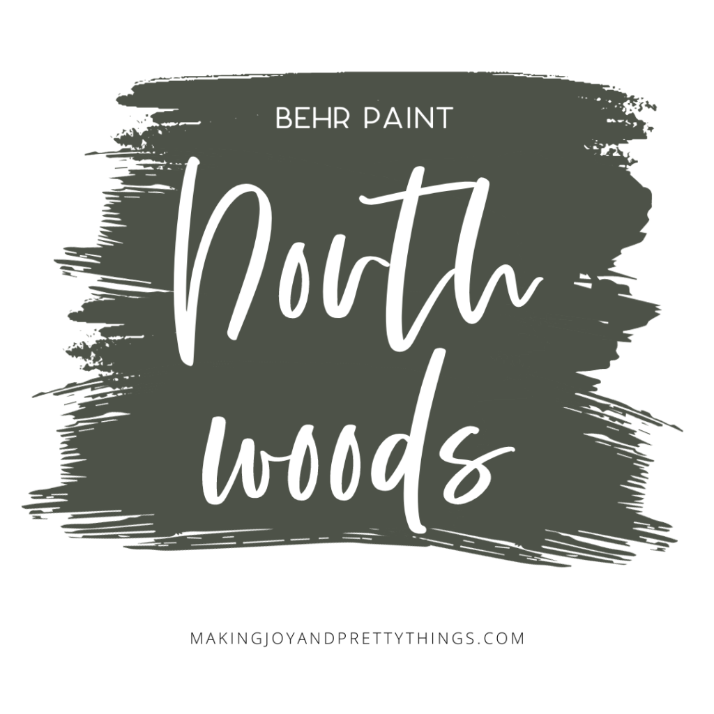 A photo of a graphic text with a dark green brush paint design. With text overlays saying "BEHR Paint North Woods".
