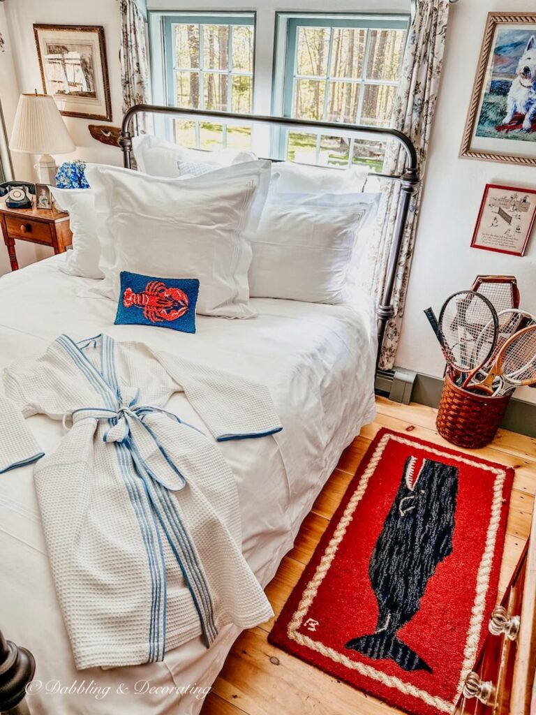 A bedroom with a red rug that has a whale print on it.