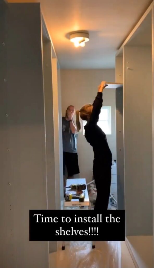 A women installing the shelves of the closet in IKEA Pax wardrobe
