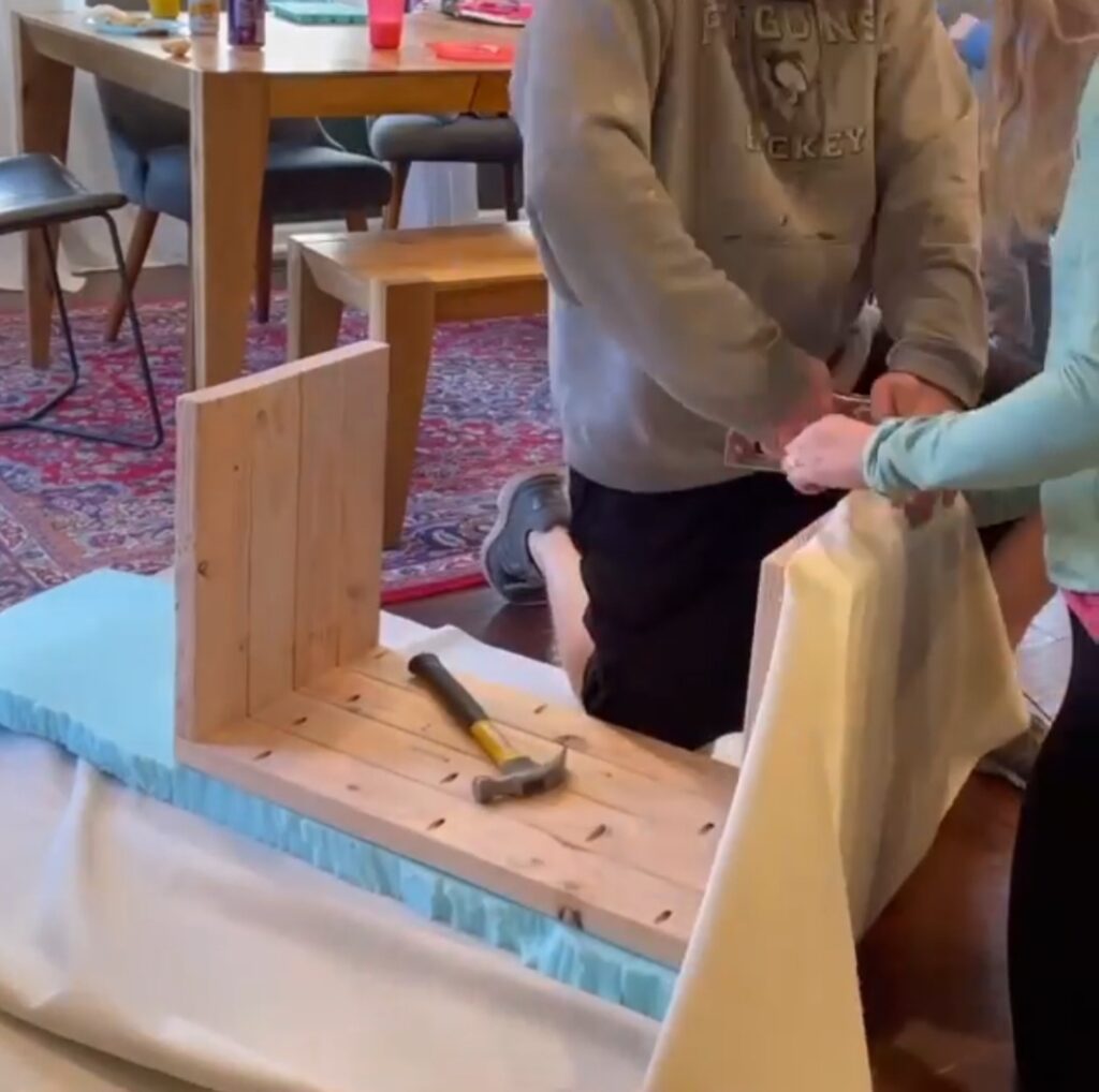 The man and woman attached the foam to the bench.