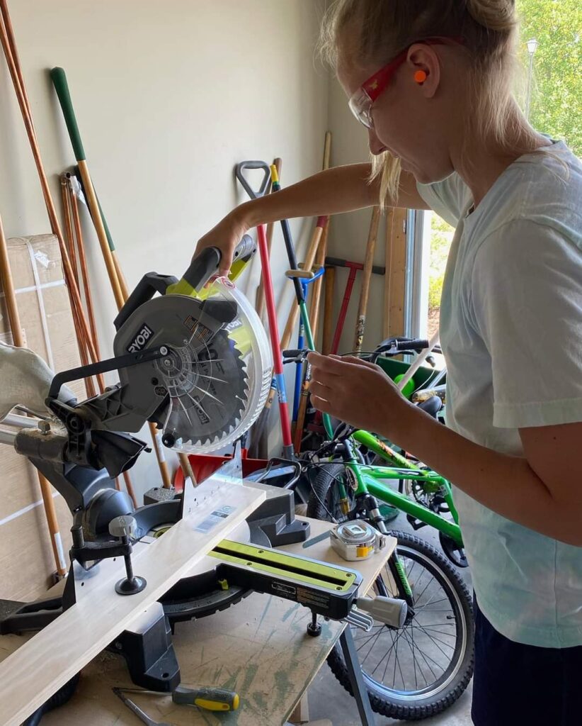 A women used the miter saw to cut the lengths of the trim for the closet.