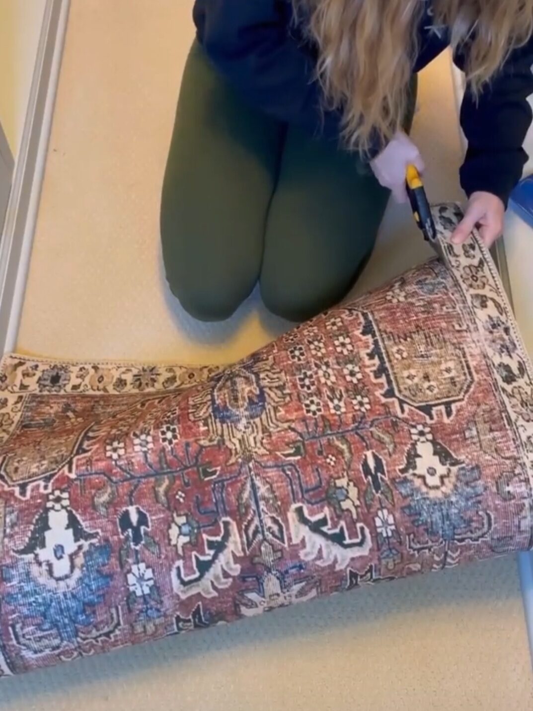 Women trimming the edges of a rug.