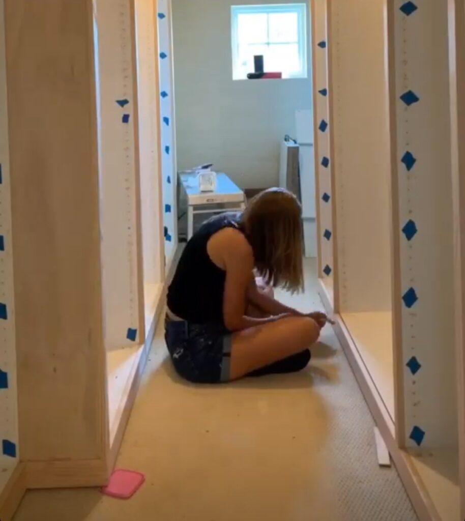 A women filling a nail holes on the trim. 