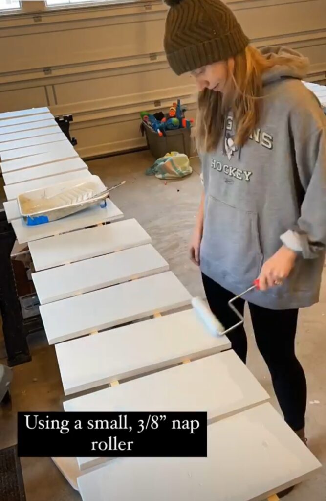 A women is painting drawer fronts for ikea closet using roller paint
