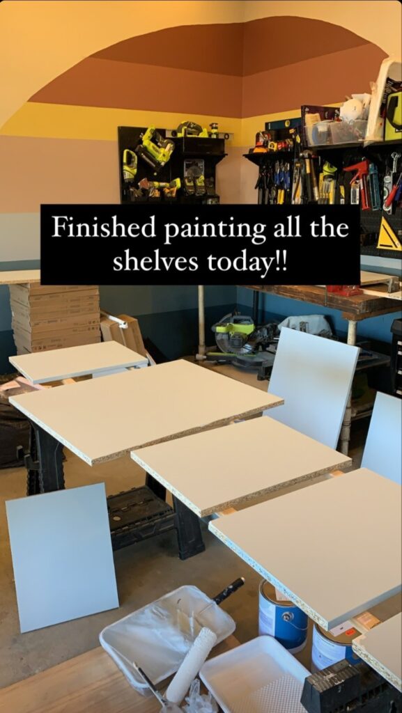 Painted shelves lay in the garage, waiting to dry.